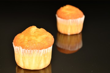 Fresh tasty muffins, close-up, on a black background.