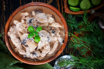 Stroganoff with chicken and mushrooms in a wooden bowl, selective focus
