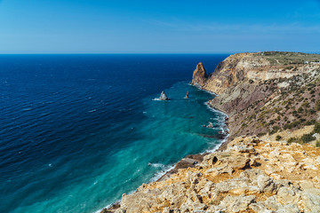 Fototapeta premium Sea bay from the height of overhanging cliffs. Violet tape in Balaklava, Sevastopol, Crimea. Bright sunny spring day, calm crystal clear blue sea. The concept of calm, silence and unity with nature