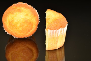 Fresh tasty muffins, close-up, on a black background.