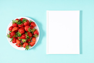 Strawberries. Blank frame for text, juicy strawberries on pastel blue background. Flat lay, top view, copy space
