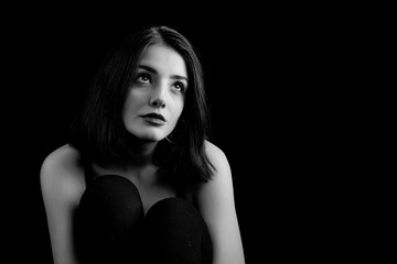 Naklejka premium Black and white young woman looking at camera isolated on black background. Beautiful woman portrait.