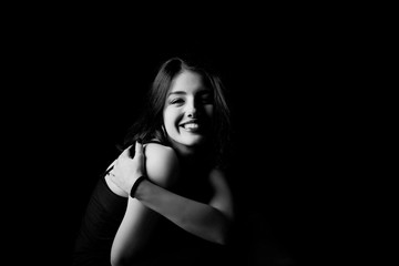 Naklejka premium Black and white young woman looking at camera isolated on black background. Beautiful woman portrait.