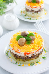 Beautiful festive layered salad with chicken, potatoes, carrots, pickles and fried champignons, selective focus