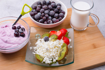 Cottage cheese with fresh summer berries in a bowl, top view of the table. Healthy dairy product rich in calcium and protein homemade milk.