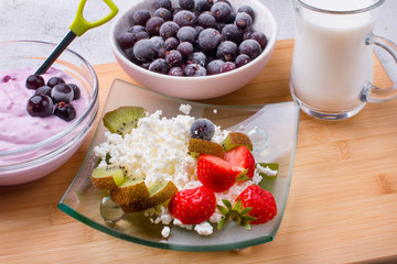 Cottage cheese with fresh summer berries in a bowl, top view of the table. Healthy dairy product rich in calcium and protein homemade milk.