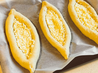 Harvest of khachapuri in Adjara on baking paper on a baking sheet