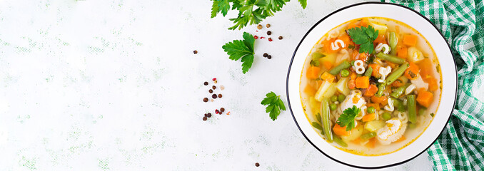 Minestrone, italian vegetable soup with pasta on light table. Top view, banner, copy space