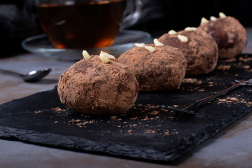 Kartoshka cake on the slate platter on the grey wooden table. Russian potato-shaped dessert