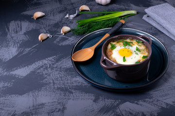 Garlic bread soup with egg baked in the oven in a portion saucepan. Copy space