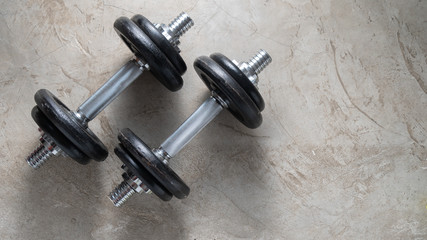 Obraz na płótnie Canvas Dumbbells for muscle building exercise placed on cement floor with copyspace.Body workout in the gym training concept.new normal popular lifestyles for strong and healthy bodybuilding at home