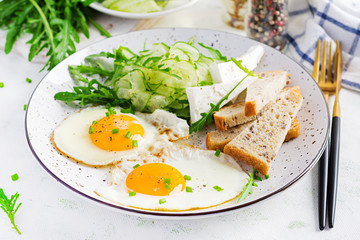 English breakfast - fried eggs, feta cheese, cucumber and arugula. American food.