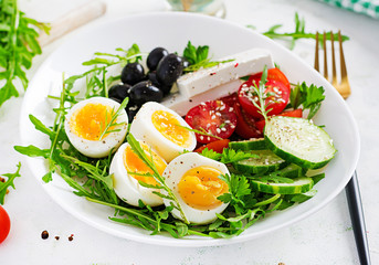 Breakfast. Greek salad and boiled eggs.  Fresh vegetable salad with tomato,  cucumbers, olives, arugula and feta cheese. Trend food.