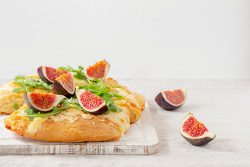 cut into pieces Italian bread with cheese, figs and arugula