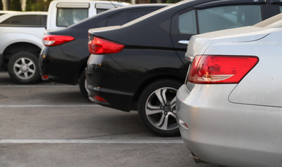 Fototapeta premium Closeup of rear, back side of bronze car with other cars parking in outdoor parking area.