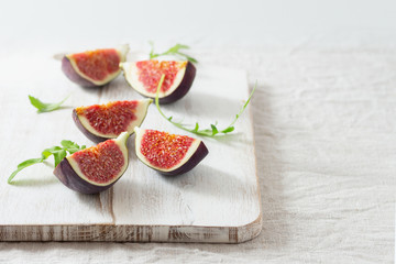 ripe figs and arugula on a chopping board