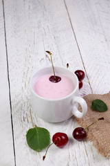 White cup with yogurt, cherries and mint. A wonderful breakfast and a great start to the day, healthy nutrition for weight loss and skin improvement