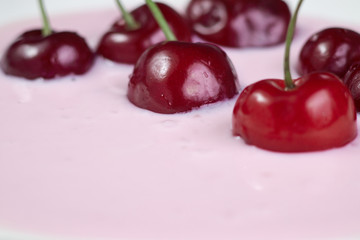 Red cherry in yogurt close-up, healthy breakfast and good morning mood