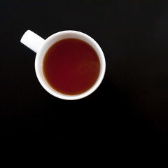 Cup of tea on black table, top view