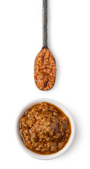 Bowl and spoon with red pesto sauce