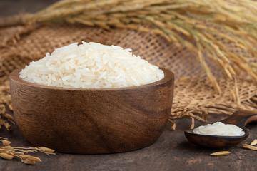 rice.white rice (Thai Jasmine rice) in wooden bowl on wood background.Jasmine Rice in bowl and burlap sack on wooden table