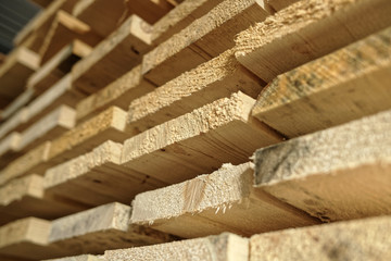 Construction lumber. Dry boards are stacked. A close-up of wood in the end. The background for the woodworking industry and sawmills