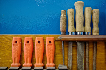 The carpenter's tools hang neatly on the wall. Workplace order. Rashpil, file and chisel close-up....