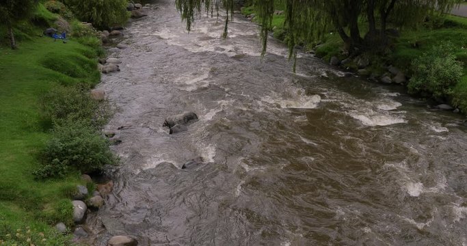 River flowing through a park, Rio tomebamba, Cuenca, Ecuador. Tilt reveal