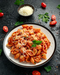 Conchiglie rigate pasta with chickpeas in tomato sauce with parmesan cheese. Healthy vegan food.