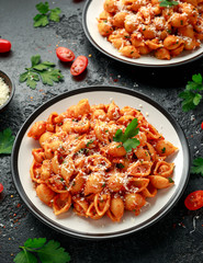 Conchiglie rigate pasta with chickpeas in tomato sauce with parmesan cheese. Healthy vegan food.