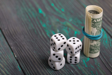 Dice are white. Near dollars rolled up in a tube. On brushed pine boards.