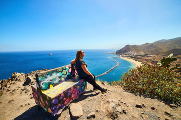 Woman traveler tourist looking at beach view. Playa de las Teresitas, Tenerife, Canary Islands, Spain.