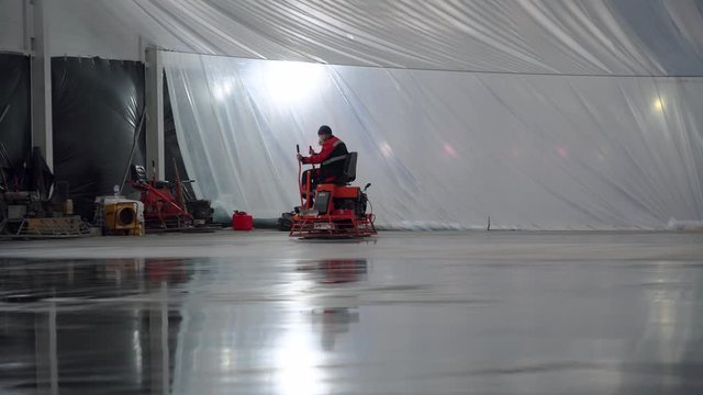 Grinding concrete pavement, Power trowel machine at construction site, Smooths concrete with a power trowel, Construction workers polishing concrete surface at construction site