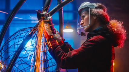 Portrait of Talented Innovative Tomboy Female Artist Using an Angle Grinder to Make Abstract,...