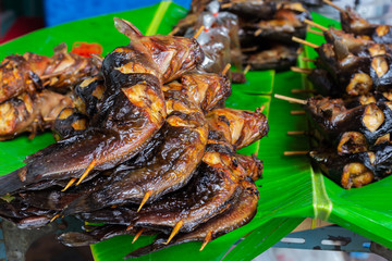 grilled catfish on banana leaf, asian food culture in street food market, thai food