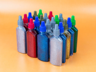 Multi-colored tubes with glitter on a yellow background