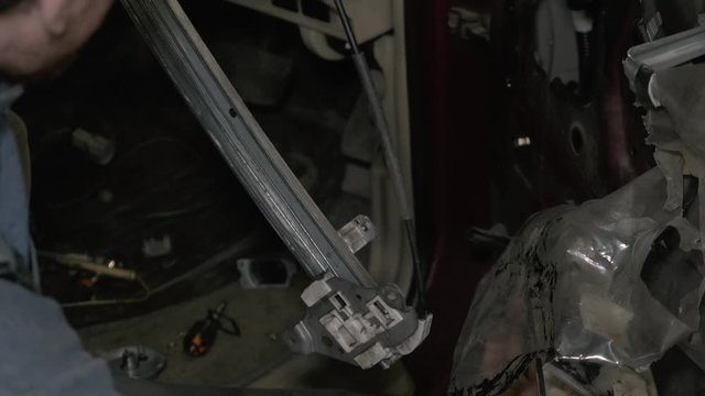 Close up view of car window regulator motor working. Car repair serviceman occupation.