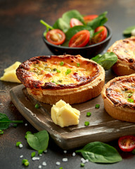Cheddar cheese and spring onion omelette tarts served on wooden board with side salad. Healthy breakfast food