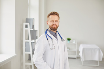 Male doctor pediatrician standing in the white office of the hospital.