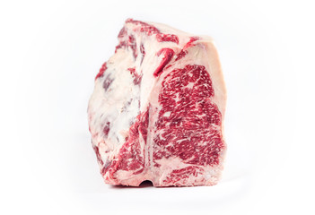 Raw dry aged wagyu porterhouse beef block offered as closeup on white background with copy space -...