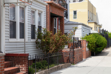 Fototapeta na wymiar Astoria Queens New York Neighborhood Homes and Sidewalk