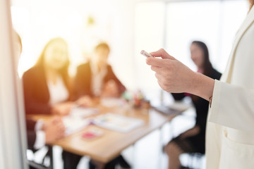 close up hand, hand holding laser pen and  point to information board, presenter and team discuss about strategy plan and knowledge sharing