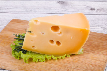 Maasdam cheese  in the board served salad leaves