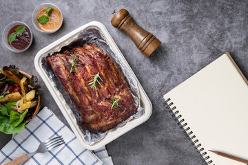 Grilled pork ribs with Vegetables and sauces on a drak table