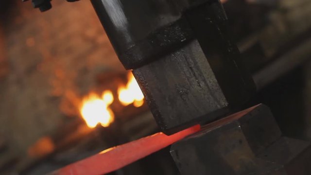 blacksmith hammer on the anvil against the background of fire