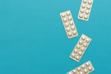 Blister packs with pills on a blue background, lowering blood cholesterol with statin tablets