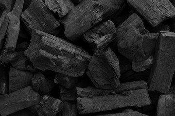 Natural fire ashes with dark grey black coals texture. It is a flammable black hard rock.  Space for text.