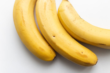 Three yellow ripe bananas on a white background, close-up, macro. Food photos.