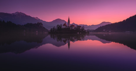 Tranquility Winter Rising Of The Sun At  Lake Bled, Slovenia.Windless Reflection Church of Mary the Queen, Parish Church Of St.Martin And Smoke On The Water.Perfect Combination Architecture And Nature - 352222977