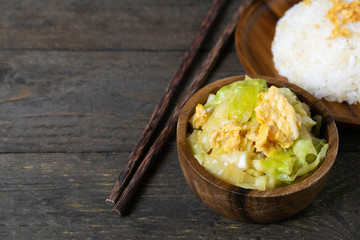 Fried cabbage and fried egg in oyster sauce, Rice in wooden dish.